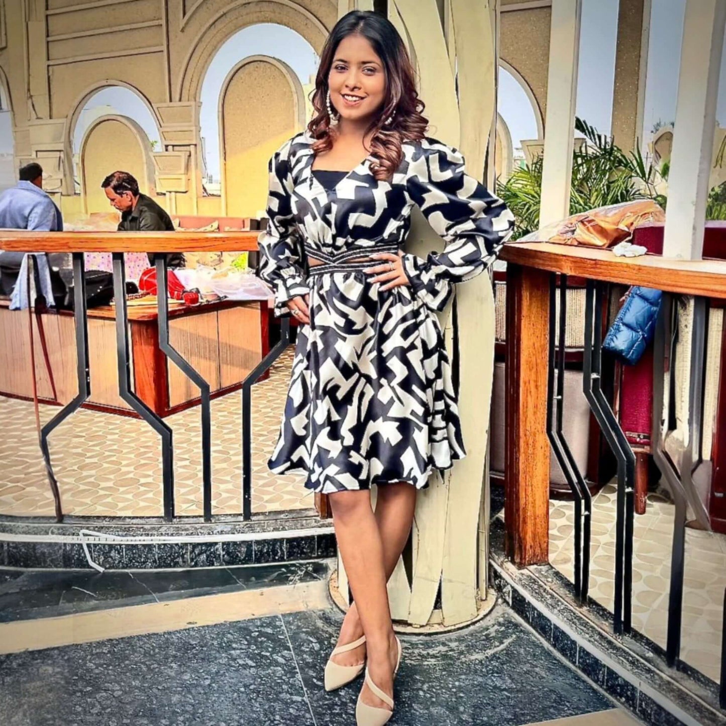 A woman elegantly styled in House Of Majisha's Chic Monochrome Dress, showcasing a striking black and white abstract print with trendy puff sleeves, perfect for brunch dates or evening parties.