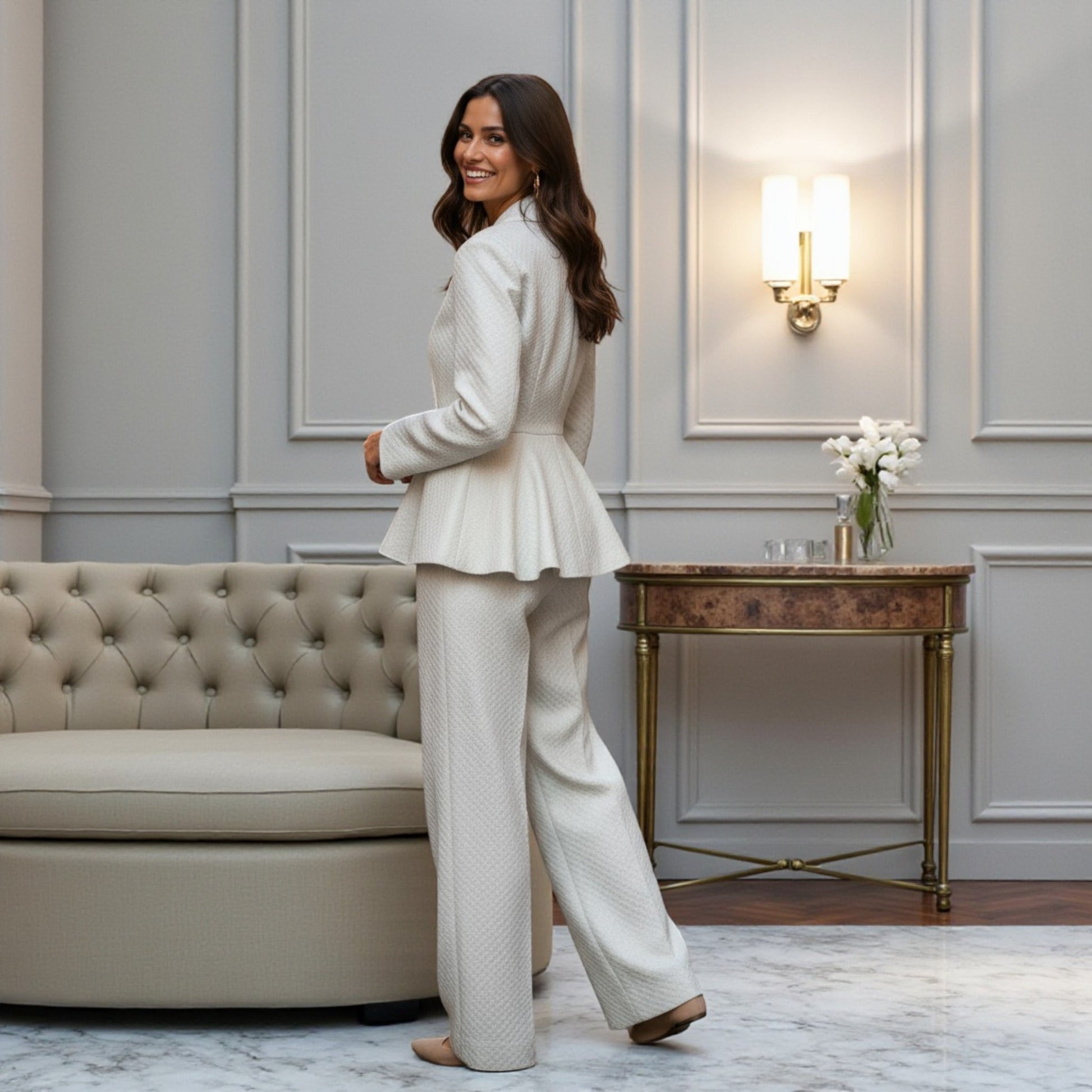 Indian model wearing the Ivory Grace Peplum Pantsuit by House of Majisha an ivory textured peplum blazer and wide leg pants styled in an elegant marble-floor room.