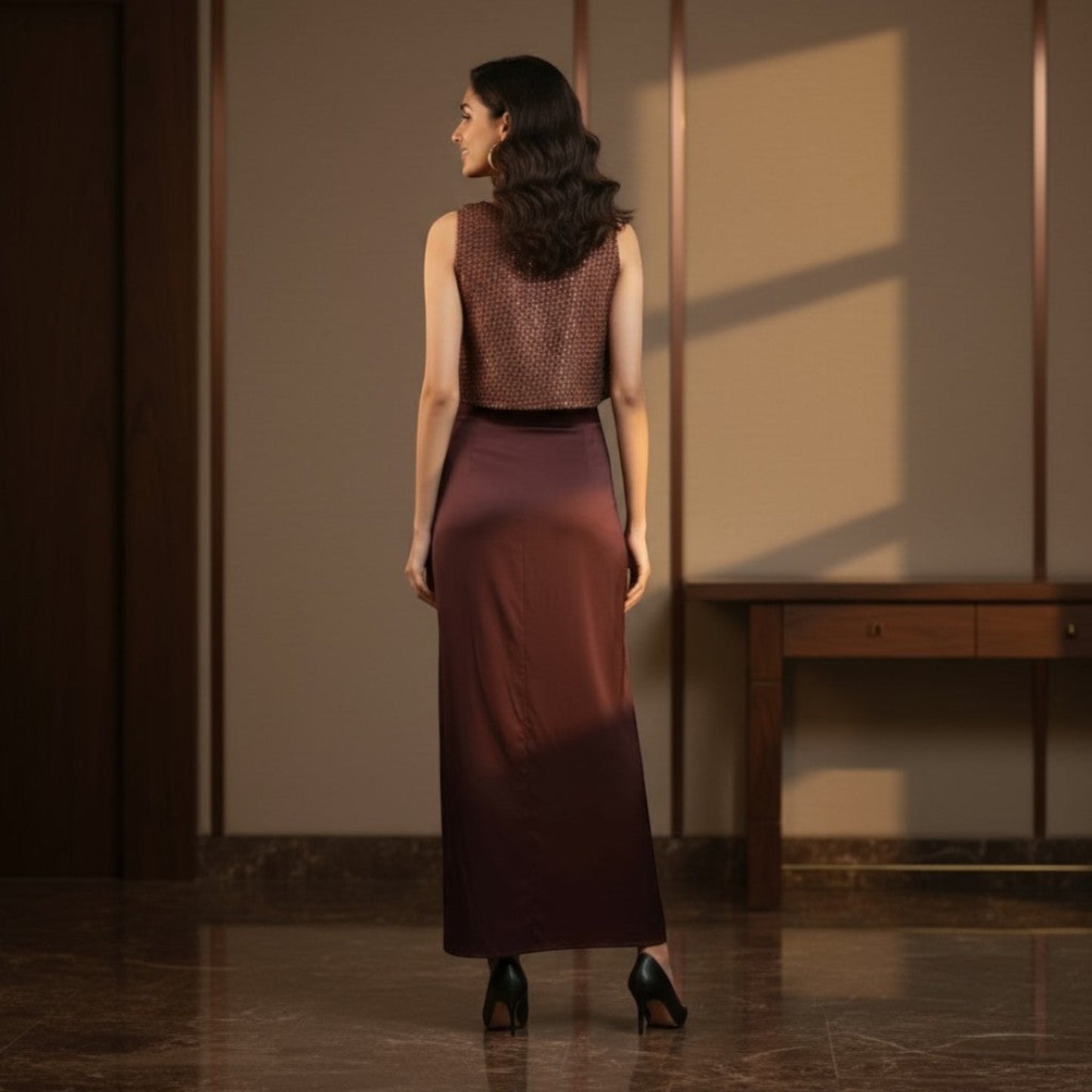 Indian model wearing the Mocha Drape Satin Coord Set by House of Majisha sleeveless textured crop top and draped slit skirt in mocha satin styled in a warm indoor setting.