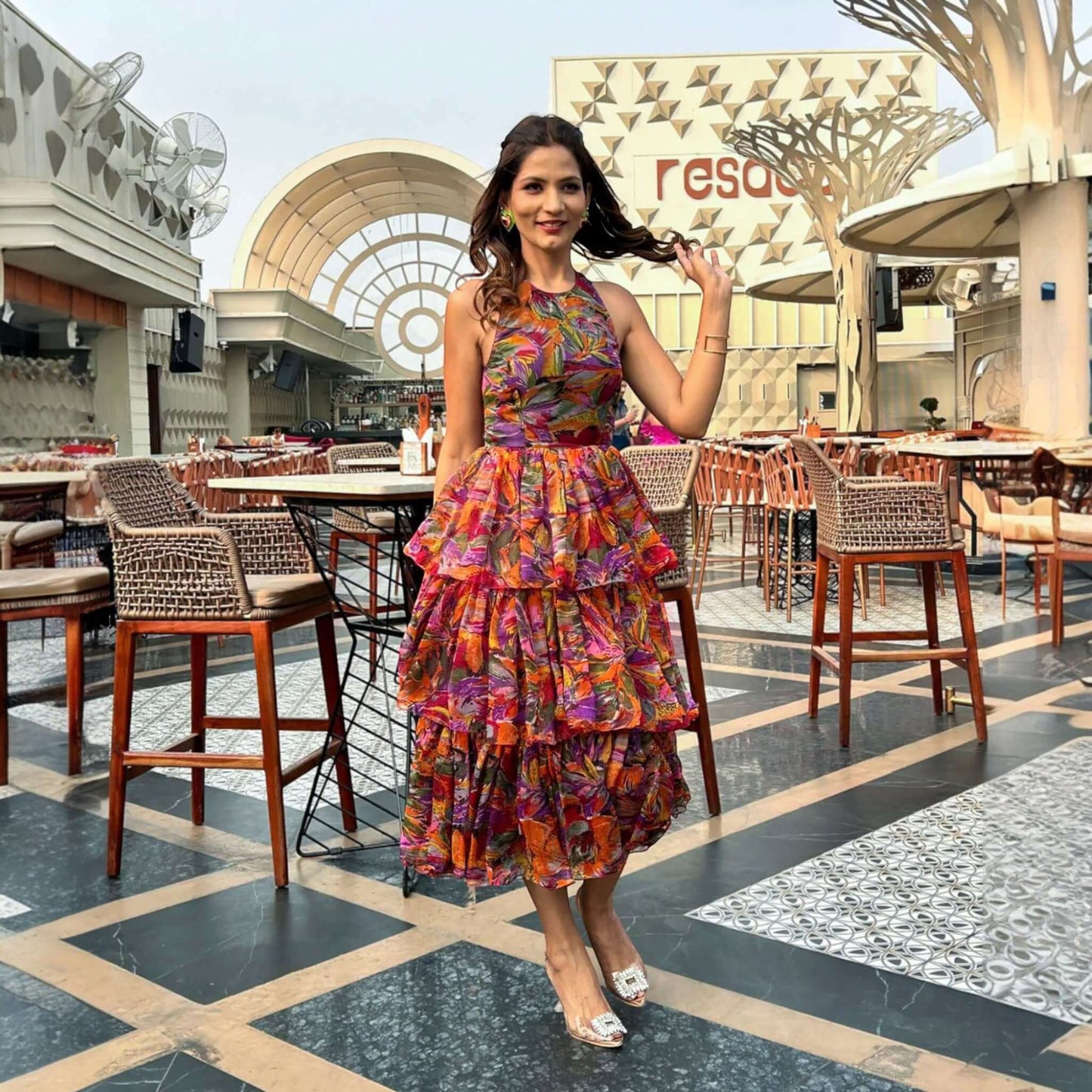 A vibrant multicolor chiffon halter neck dress with ruffles and a flared design from House Of Majisha, perfect for picnics, brunches, or vacation, featuring a backless style and full-length flowy silhouette.