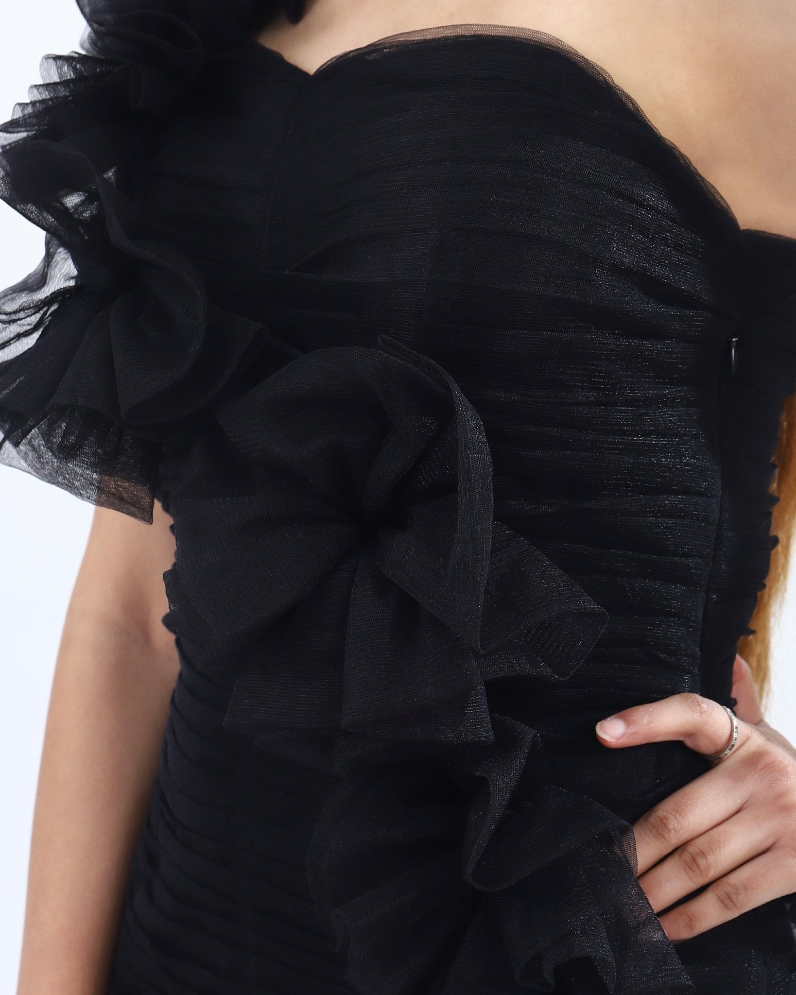 Black cocktail dress with strapless design, ruffles cascading down one side, knee-length hem.