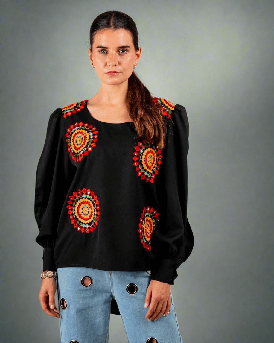 Women wearing a black top with red and yellow embroidery work done on it 