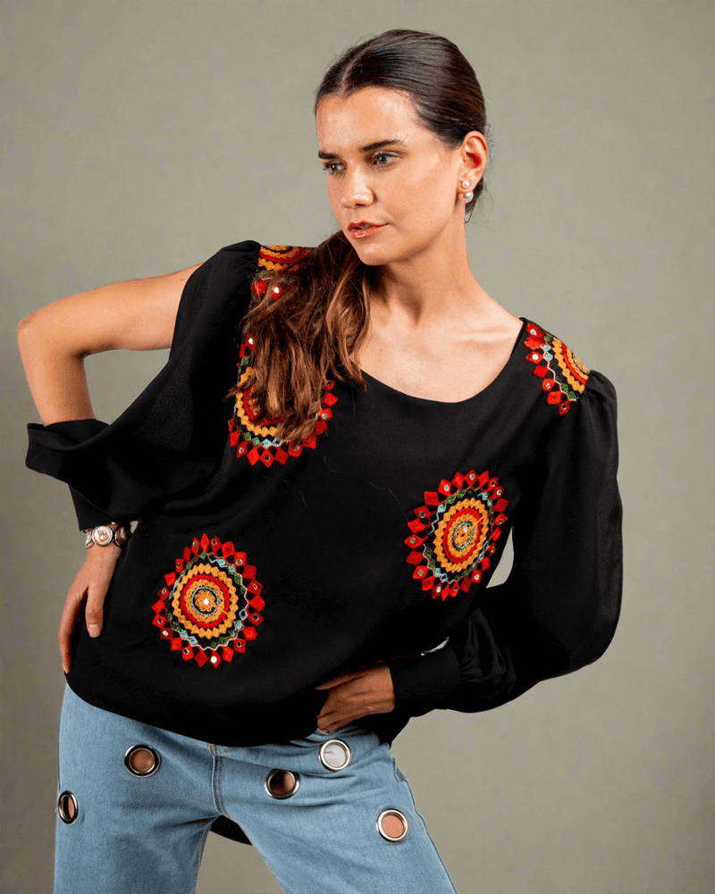 Women wearing a black top with red and yellow embroidery work done on it 