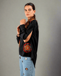 Women wearing a black top with red and yellow embroidery work done on it 