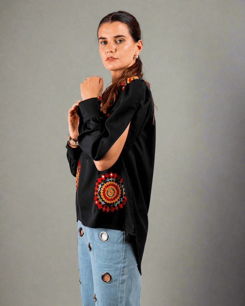 Women wearing a black top with red and yellow embroidery work done on it 