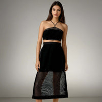 Model showcasing the Boho Beach Set featuring a black crochet net top with a criss-cross neckline and a sheer skirt, perfect for beach outings from House of Majisha.