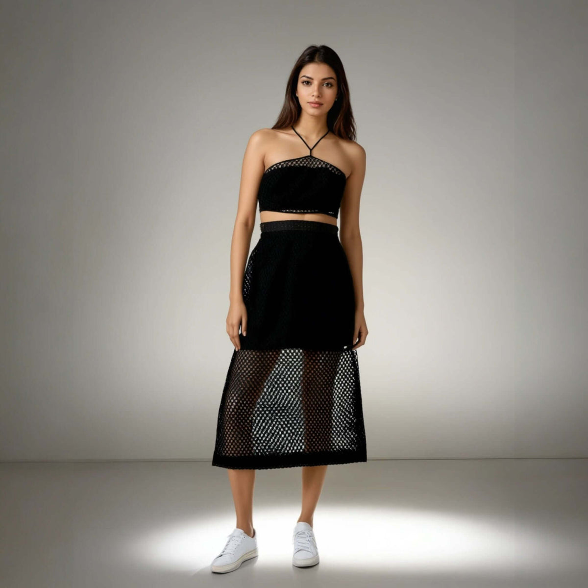Model showcasing the Boho Beach Set featuring a black crochet net top with a criss-cross neckline and a sheer skirt, perfect for beach outings from House of Majisha.