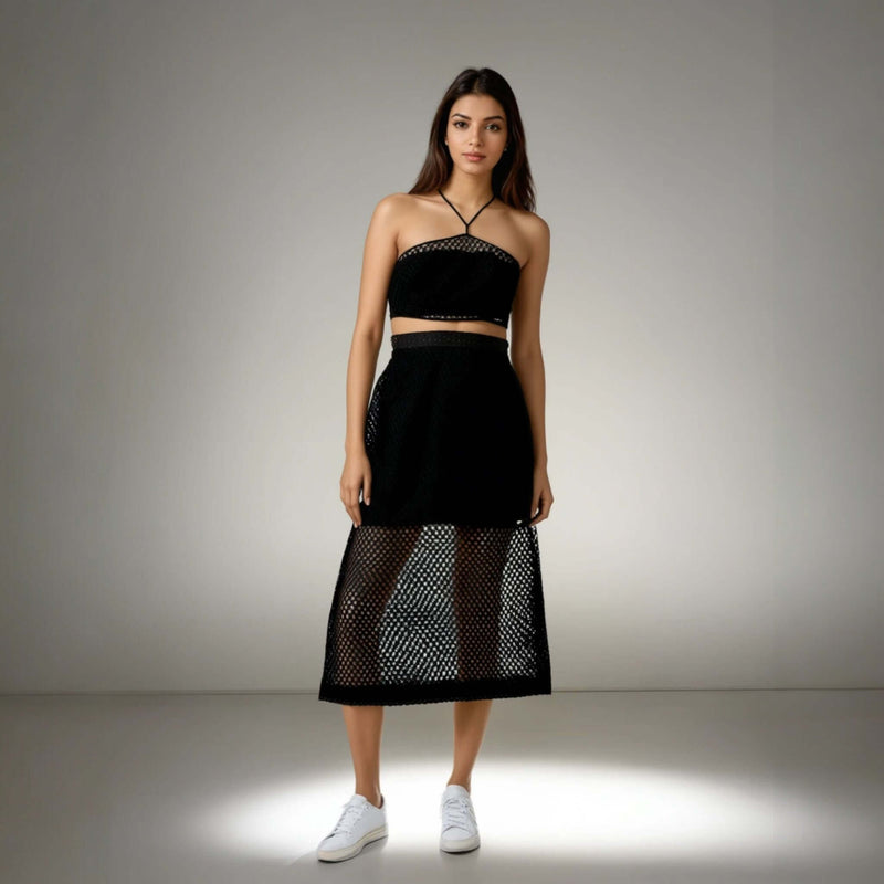 Model showcasing the Boho Beach Set featuring a black crochet net top with a criss-cross neckline and a sheer skirt, perfect for beach outings from House of Majisha.