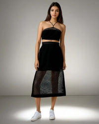 Model showcasing the Boho Beach Set featuring a black crochet net top with a criss-cross neckline and a sheer skirt, perfect for beach outings from House of Majisha.