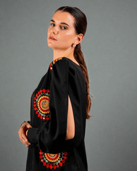 Women wearing a black top with red and yellow embroidery work done on it 