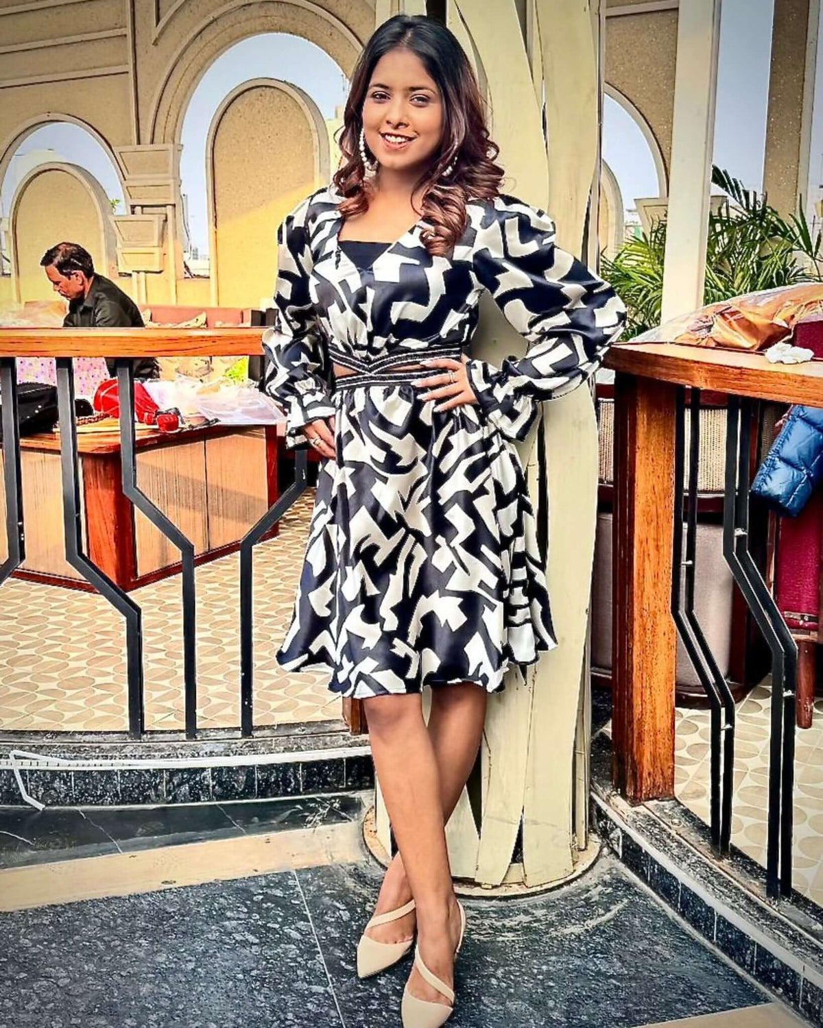 A woman elegantly styled in House Of Majisha's Chic Monochrome Dress, showcasing a striking black and white abstract print with trendy puff sleeves, perfect for brunch dates or evening parties.