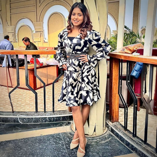 A woman elegantly styled in House Of Majisha's Chic Monochrome Dress, showcasing a striking black and white abstract print with trendy puff sleeves, perfect for brunch dates or evening parties.