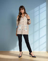 A model poses in a beige oversized button-down shirt featuring bold black buttons and colorful tribal-inspired printed pockets from House Of Majisha. The relaxed fit and statement pocket design add a touch of bohemian charm, making it a stylish choice for casual wear.