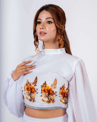 White crop top with vibrant orange and brown floral prints, featuring a high neckline and sheer balloon sleeves on a stylish woman