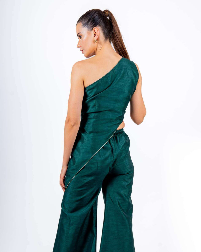 Woman wearing emerald green off-shoulder coord set with asymmetrical top and flared palazzo pants, perfect for evening parties and clubwear.