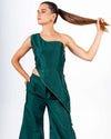 Woman wearing emerald green coord set with off-shoulder asymmetrical top and flared palazzo pants.