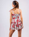 Woman wearing a white and red floral cut-out skater dress with a sweetheart neckline, perfect for summer beach, club, and party wear.