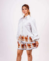 Woman wearing white floral coord set with classic collar shirt and relaxed shorts made from soft twill cotton, featuring autumn leaves design.