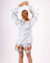 Woman wearing white floral coord set with long-sleeve shirt and relaxed shorts, back view.