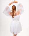 Rear view of a white organza balloon dress with voluminous sleeves and a tied belt, showcasing its elegant and whimsical design.