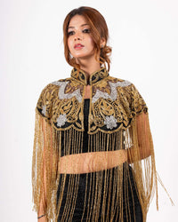 Elevate your style with this luxurious cape, adorned with intricate gold embroidery and elegant fringe for a bold, glamorous finish