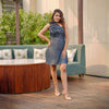 Woman wearing the Chic Denim Delight one-shoulder dress with handmade flower patches, perfect for brunches, casual dates, and evening parties.