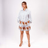 Woman wearing white floral coord set with loose shirt and relaxed shorts featuring a beautiful printed floral design.