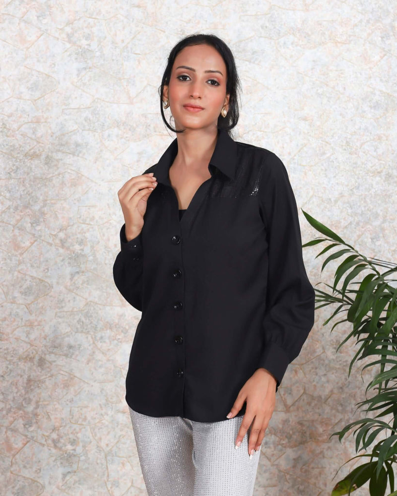 A Women wearing a stylish black cotton shirt, featuring a shimmering sequin details and chic design, perfect for summer evenings and semi-formal occasions.