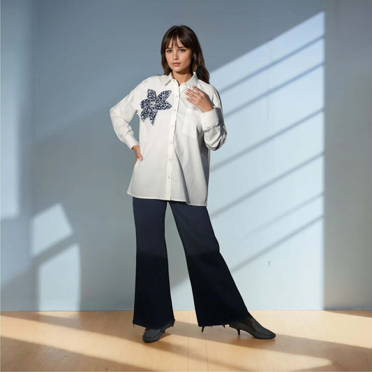 Model showcasing the Chic White Blossom Shirt in white, featuring a floral design, styled with dark trousers for a trendy casual look from House Of Majisha
