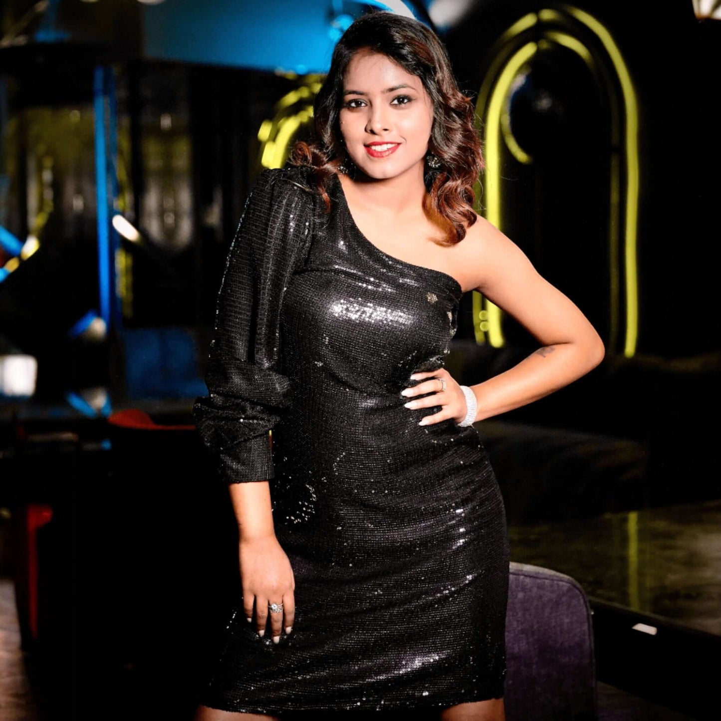Woman wearing a stunning Black Dress, Midnight Sparkle One-Shoulder Black Sequin Dress, featuring dazzling sequins and a chic one-shoulder design.