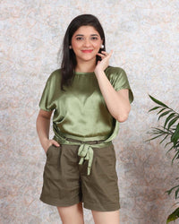 Woman wearing olive satin top with tie-front detail and brown shorts from House Of Majisha