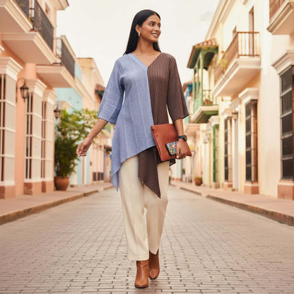 Woman walking down a sunlit street wearing a blue and brown Shoreline Split Tunic by House Of Majisha.