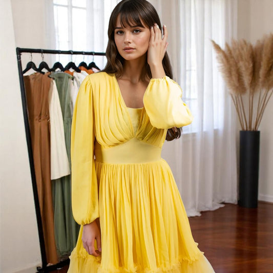 Model posing for a camera wearing a yellow dress from house of majisha, the model is standing and posing for a camera in a women clothing showroom.