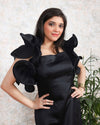 Chic black satin dress featuring large ruffled sleeves and a knee-length silhouette.