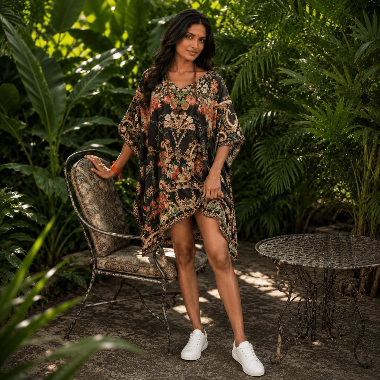 Woman in a house of majisha floral kaftan dress standing in a garden setting