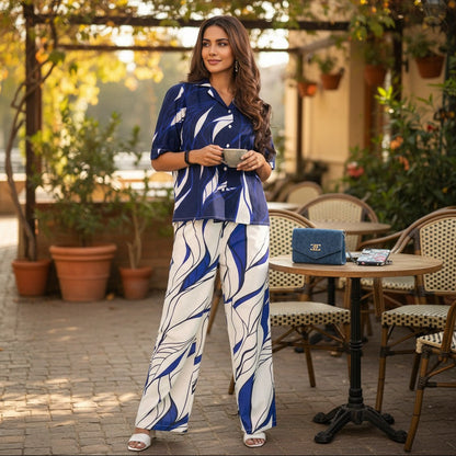 Woman wearing navy blue abstract leaf printed co ord set with matching shirt and pants.