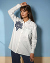 Model showcasing the Chic White Blossom Shirt in white, featuring a floral design, styled with dark trousers for a trendy casual look from House Of Majisha