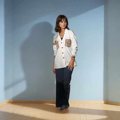 Model wearing a white Chic Patchwork Shirt with colorful patchwork pockets, styled casually with dark pants, showcasing modern fashion from House of Majisha.