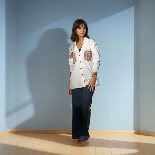 Model wearing a white Chic Patchwork Shirt with colorful patchwork pockets, styled casually with dark pants, showcasing modern fashion from House of Majisha.