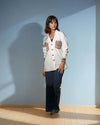 Model wearing a white Chic Patchwork Shirt with colorful patchwork pockets, styled casually with dark pants, showcasing modern fashion from House of Majisha