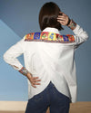 Model wearing a white Chic Patchwork Shirt with colorful patchwork pockets, styled casually with dark pants, showcasing modern fashion from House of Majisha