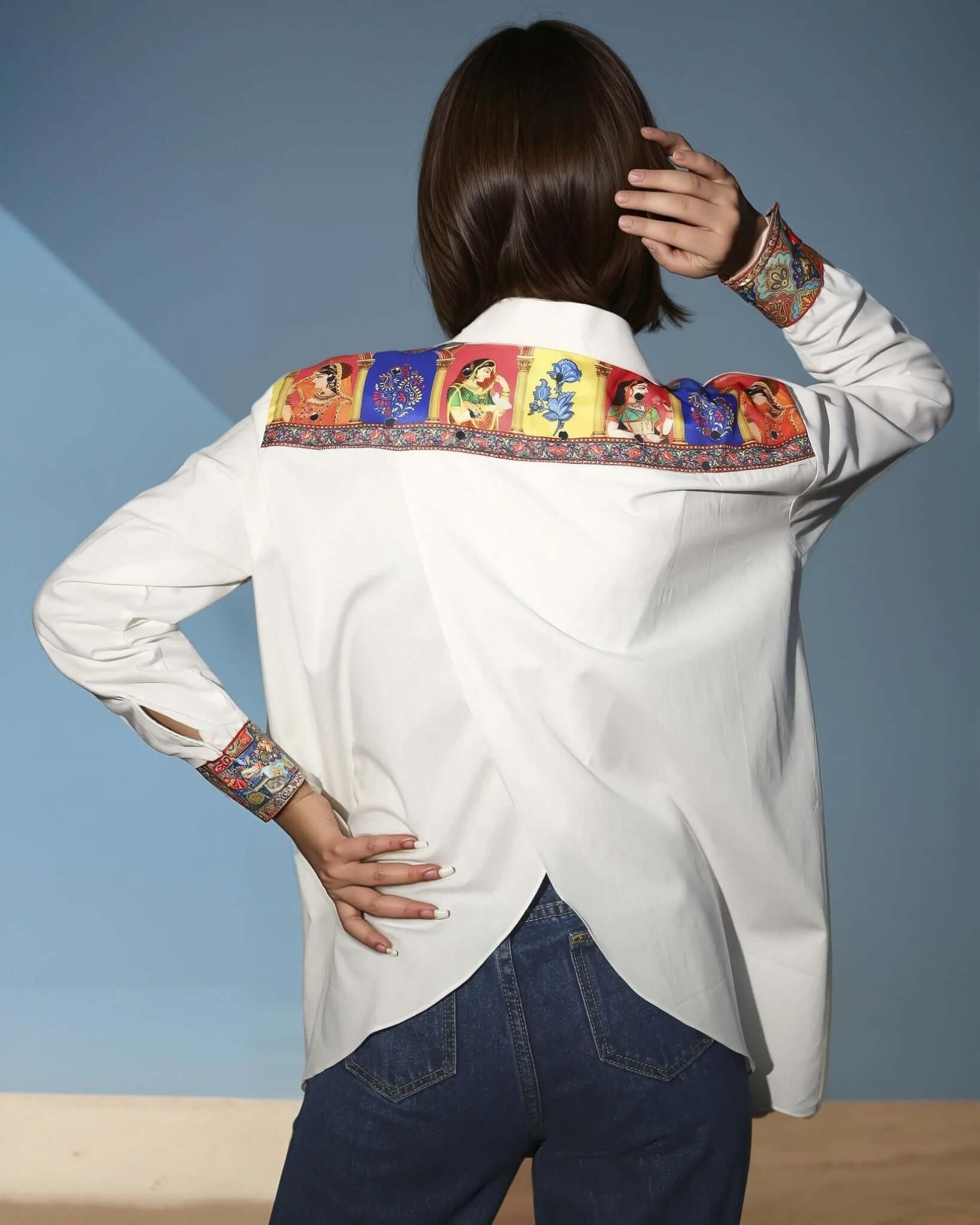 Model wearing a white Chic Patchwork Shirt with colorful patchwork pockets, styled casually with dark pants, showcasing modern fashion from House of Majisha