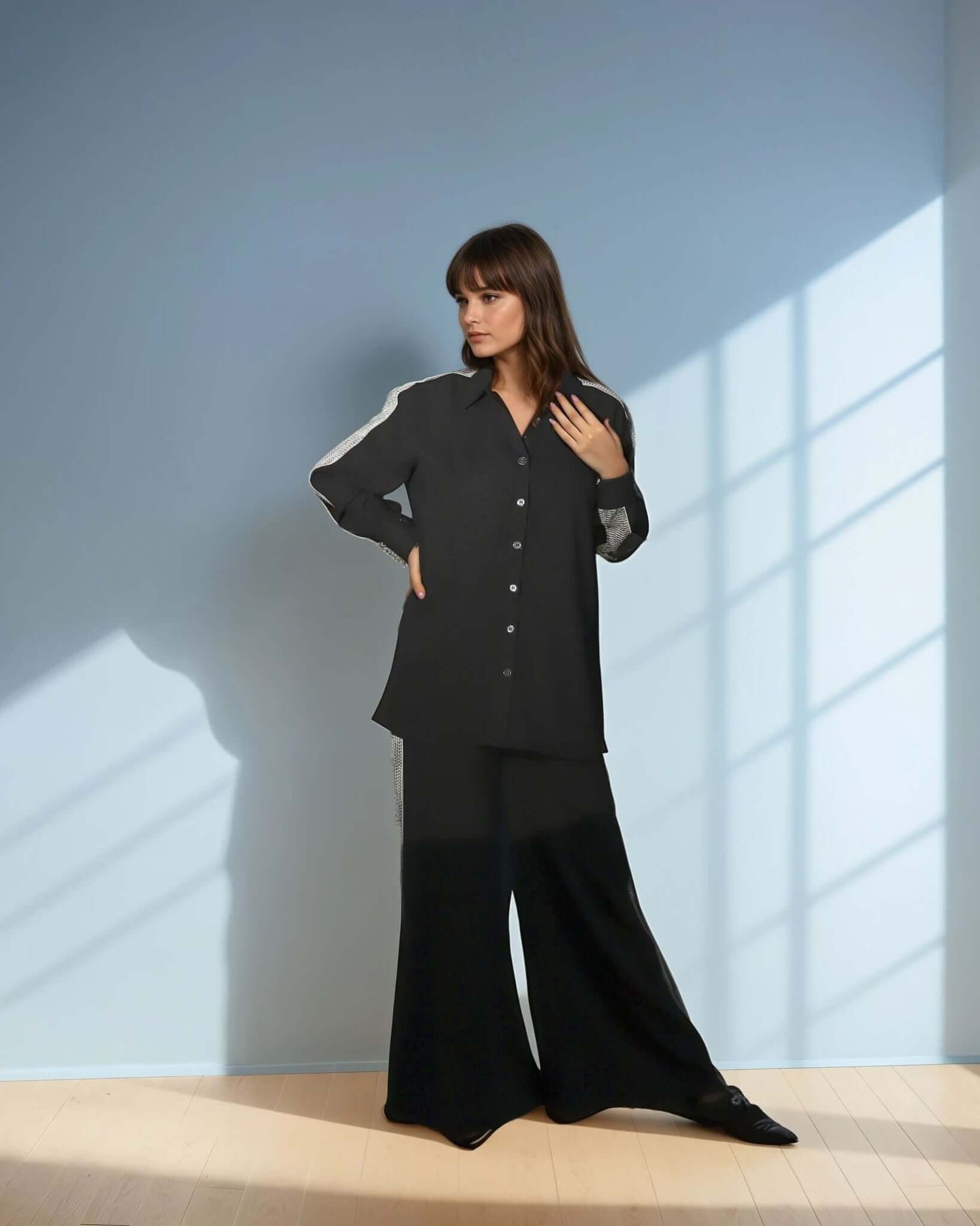 Model wearing a chic black shirt from House of Majisha, showcasing a trendy button-up design in a stylish indoor setting.