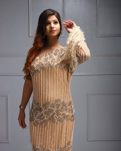 One shoulder beaded dress with feather sleeve, cutdana work, sequin detail, and sheer overlay.