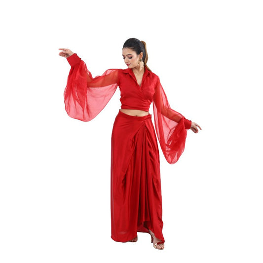 Bold red co-ord set for women featuring a low-cut neckline top with billowy sleeves and a high-waisted skirt with a slit for added allure.