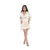 A poised woman in a cream satin wrap dress stands gracefully