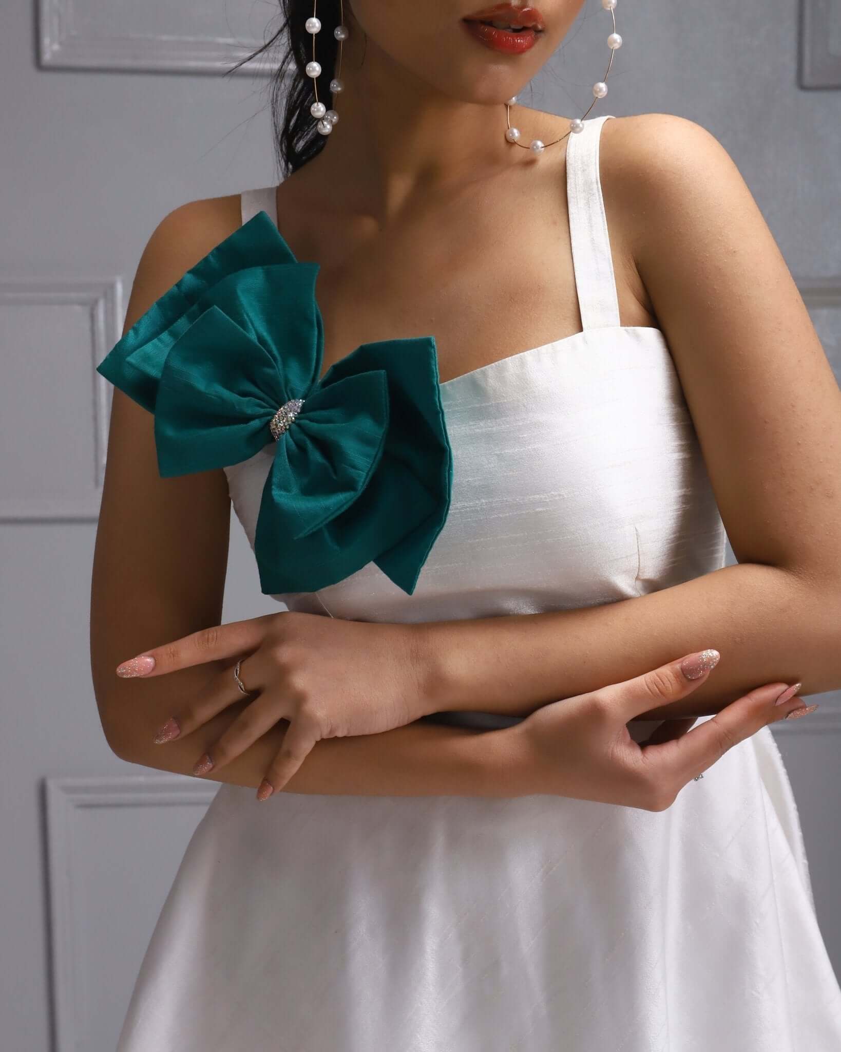 A white A-line dress with a teal bow accent, perfect for summer parties and events.