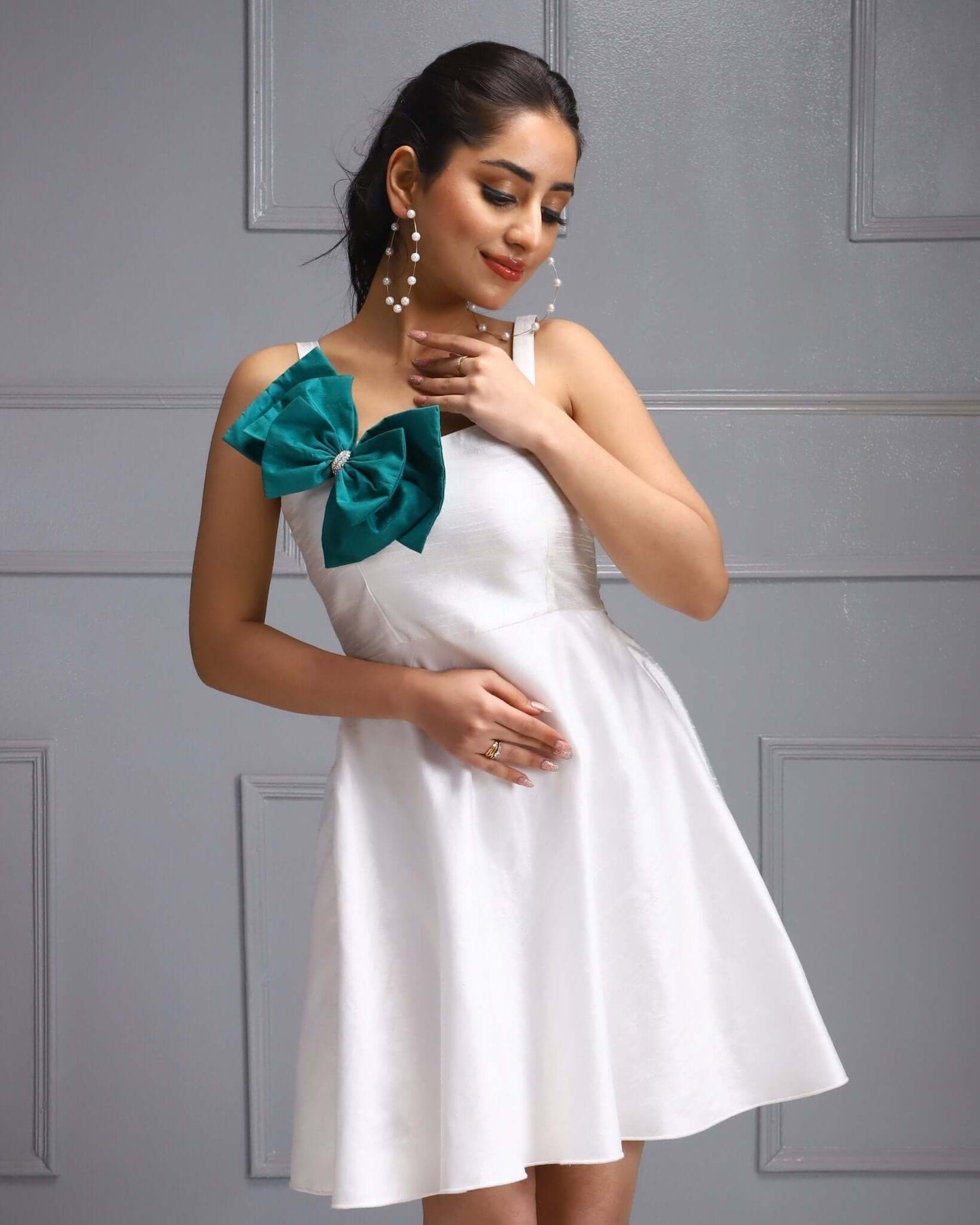 White Party Dress with a Teal Bow Accent, perfect for summer events and garden parties.